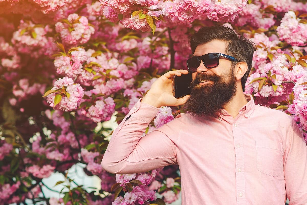 Hipster devant fleurs roses, ravi de son forfait Youprice à 5€