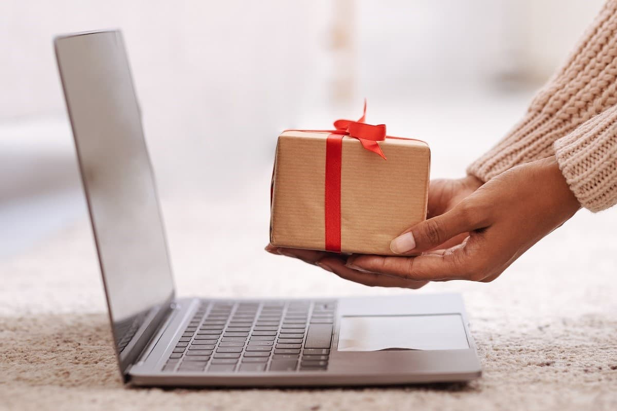 Mains présente paquet cadeau doré à PC portable, comme Orange offre 2 mois d'abonnement avec ses Livebox