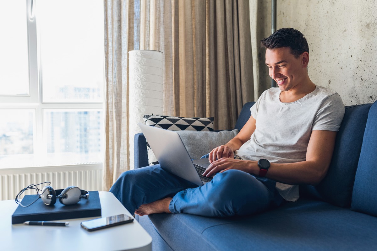 Homme content dans chambre hotel et serein car Wi-Fi efficace