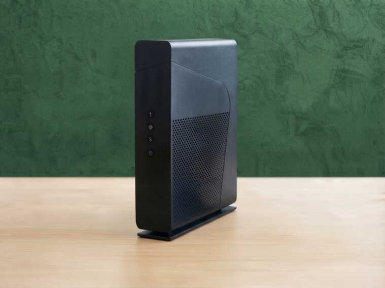 Box internet noire posée sur une table en bois devant un fond vert pour une offre éco-environnement.