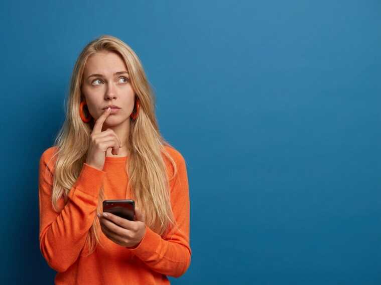 Femme blonde sur fond bleu s'interroge sur le forfait à 1.49€ de NRJ Mobile