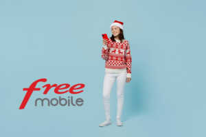 Femme avec pull et bonnet de Noël et smartphone et logo de Free Mobile, ravie de son forfait Série Free de 120 Go en 5G à moins de 9€