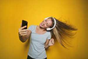 Fille avec écouteurs et smartphone écoute de la musique avec son Galaxy A15, en super promo chez Amazon