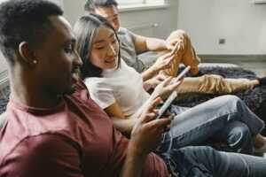 3 personnes dans canapé comparent leurs smartphones, ravies du Galaxy A06 à 100€ chez Amazon