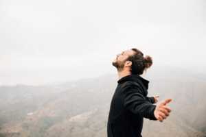 Homme bras écartés yeux fermés respire en haut de la montagne, car 120 Go de 5G dispo dès 6.99€ chez Prixtel avec le forfait "Oxygène", soit le prix d'entrée le moins cher du marché
