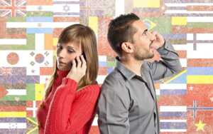 Homme et femme téléphone dos à dos sur fond de drapeaux, car nouvelle mode des forfaits "Voyage"