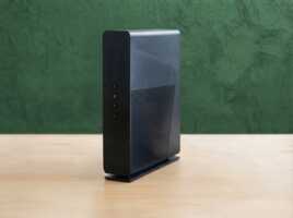 Box internet noire posée sur une table en bois devant un fond vert pour une offre éco-environnement.