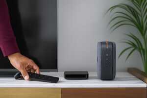 Une box internet et un décodeur sont posés près d'une TV dans un salon