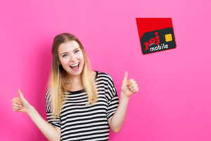 Femme en marinière sur fond rose avec logo NRJ Mobile, pouce levés car ravie de forfait illimité dès 1.49€/mois
