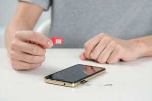 Une carte SIM rouge sortie de son smartphone