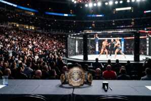 Ceinture de championnat de MMA posée sur une table officielle dans une arène de Chicago avec public en arrière-plan.
