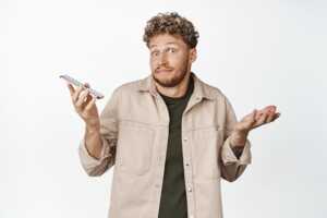 Homme avec smartphone mains levées en signe d'hésitation, doute de l'utilité d'avoir 2 SIM sur deux réseaux différents