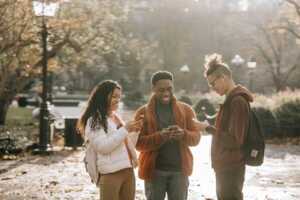 groupe de jeunes sur leurs smartphones en pleine rue