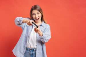 Fille sur fond rouge joue avec la manette de la PS5, proposée avec 270€ dans les offres combo "Bbox + Gaming" de Bouygues Telecom