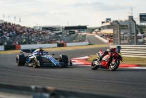 Une monoplace de Formule 1 et une moto de MotoGP roulant côte à côte sur un circuit automobile.