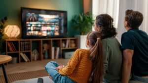 Une famille regarde la télévision sur une smart TV connectée à la fibre de Bouygues Telecom