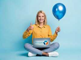 Femme assise en tailleur avec un pouce levé, un ballon bleu et un ordinateur portable avec le logo Bouygues Telecom.