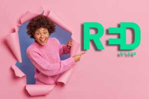 Femme sort d'un fond rose et montre logo de RED by SFR, car promo maintenue sur sa RED Box