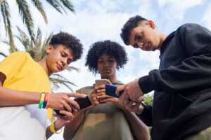 Des adolescents utilisent leur smartphone dans la cour de récréation