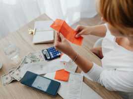 Femme regard ticket de caisse, avec smartphone sur la table, car facture du forfait peut vite monter