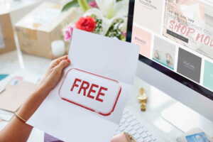 Main devant PC portable ouvre lettre avec le mot "FREE", car 1 mois d'abonnement gratuit avec la SFR Starter Box