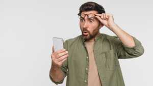 Homme soulève ses lunettes de surprise en regardant son téléphone, étonné de récupérer 10 fois plus de data chez YouPrice plutôt que chez Sosh, pour 6.99€/mois