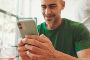 Homme regarde son smartphone et se dépèche de souscire à "Le Fast" de YouPrice, car dernier jour pour souscrire