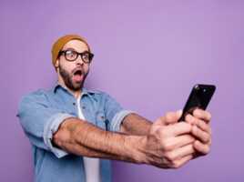 Homme surpris regarde son smartphone, car retour de Lyca Mobile avec 150Go de 5G à 7.99€