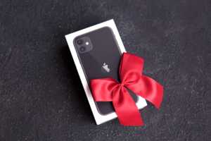 iPhone dans sa boite avec ruban rouge cadeau, car offert avec un forfait mobile de Cdiscount Mobile