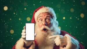 Père Noël montre smartphone en souriant, ravi des nouveaux forfaits de Syma avec appels vers l'international en bonus