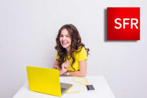 Fille en jaune devant PC jaune, sourit car possède la SFR Starter Box, la plus rapide des entrées de gamme