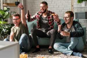 Trois amis regardent du sport à la télé, ravis de leur abonnement beIN Sports à 9€ grâce à leur livebox d'Orange