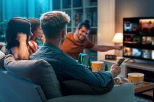 Amis contents devant la TV du salon, car Free enrichit son offre de 7 chaînes du groupe RMC-BFM