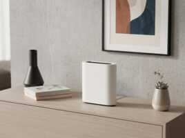 Routeur 5G blanc posé sur un meuble en bois dans un intérieur minimaliste.