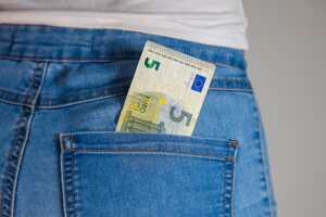 Billet de 5€ dans la poche d'un jean, soit le prix de la téléphonie illimitée avec 40 Go chez Auchan Télécom