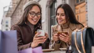 Femme avec smartphone saute de joie près du logo YouPrice, car 70Go de plus pour seulement 1€