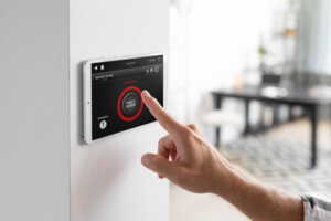 Main sur boitier de programmation de l'alarme, un service sécurité d'Orange avec "Maison protégée"