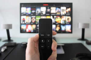 Télécommande devant TV, avec les 46 chaînes de Canal+ gratuitement avec une Freebox Ultra ou Ultra Essentiel