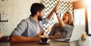 Couple devant PC portable se checke de la main, ravis de leur connexion fibre à moins de 20€ via le déstockage Bbox Wi-Fi 5 de Bouygues Telecom