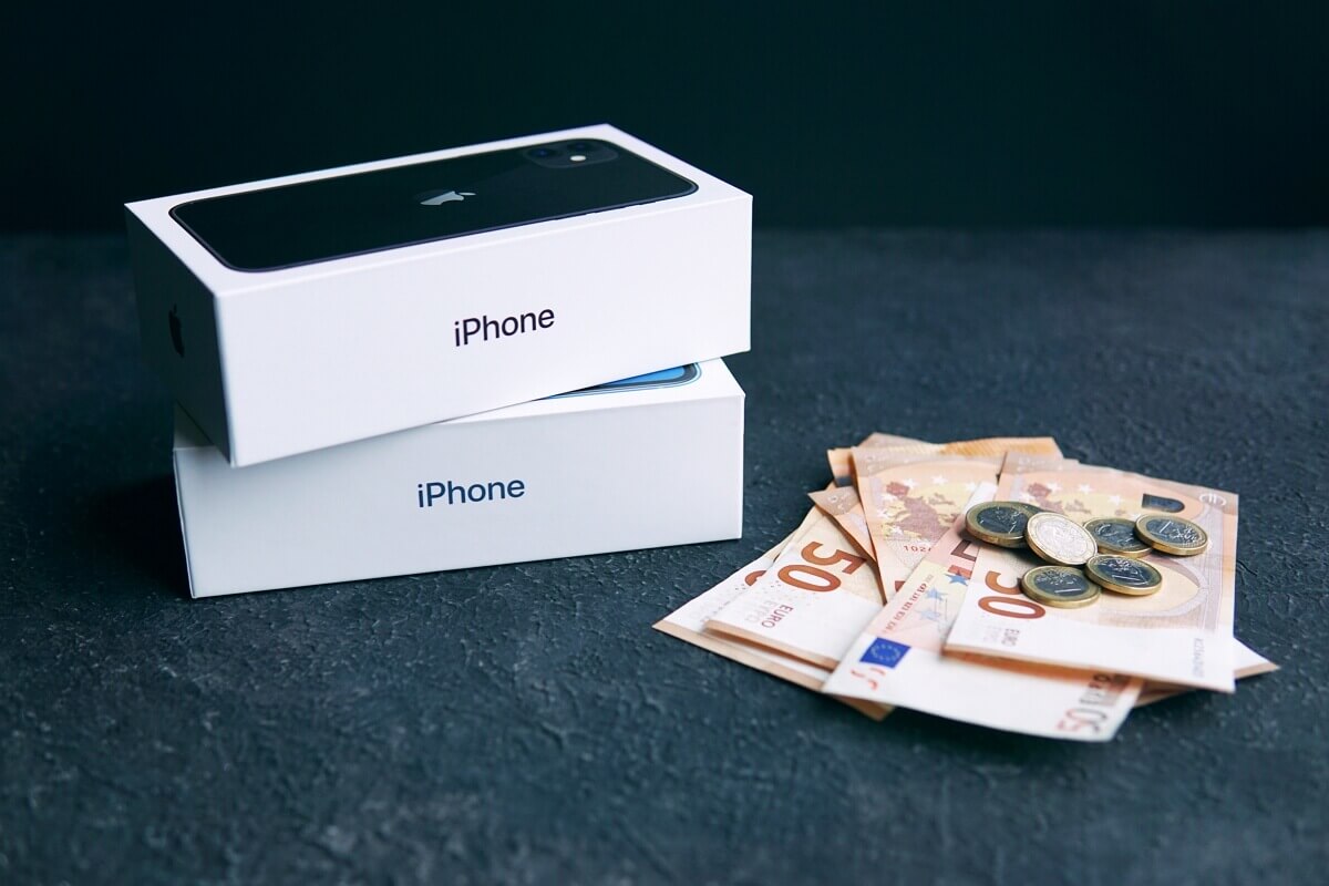 Boîte d'iPhone et argent à côté, sur fond noir, car iPhone 15 avec 15% de promo chez Amazon
