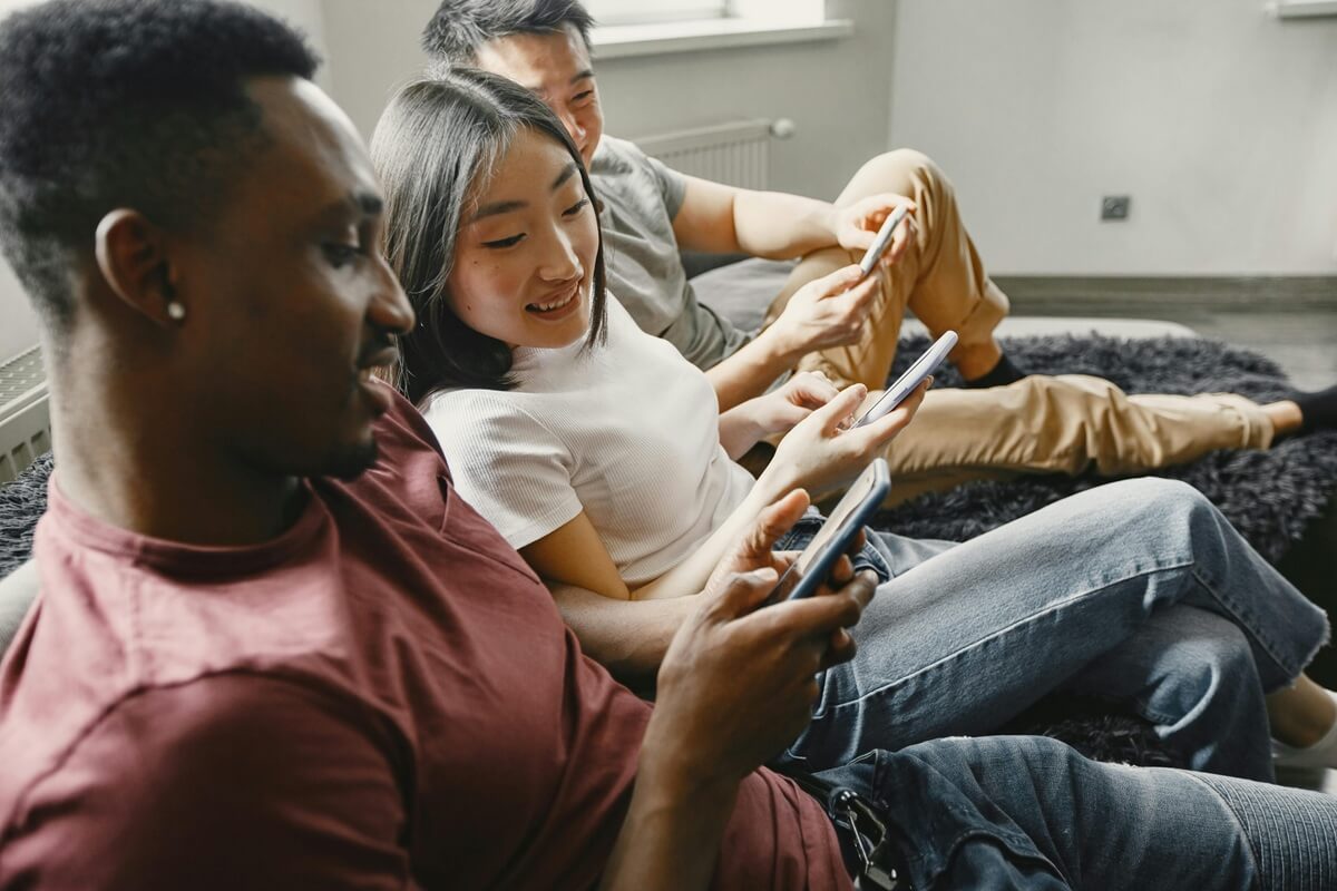 3 personnes dans canapé comparent leurs smartphones, ravies du Galaxy A06 à 100€ chez Amazon