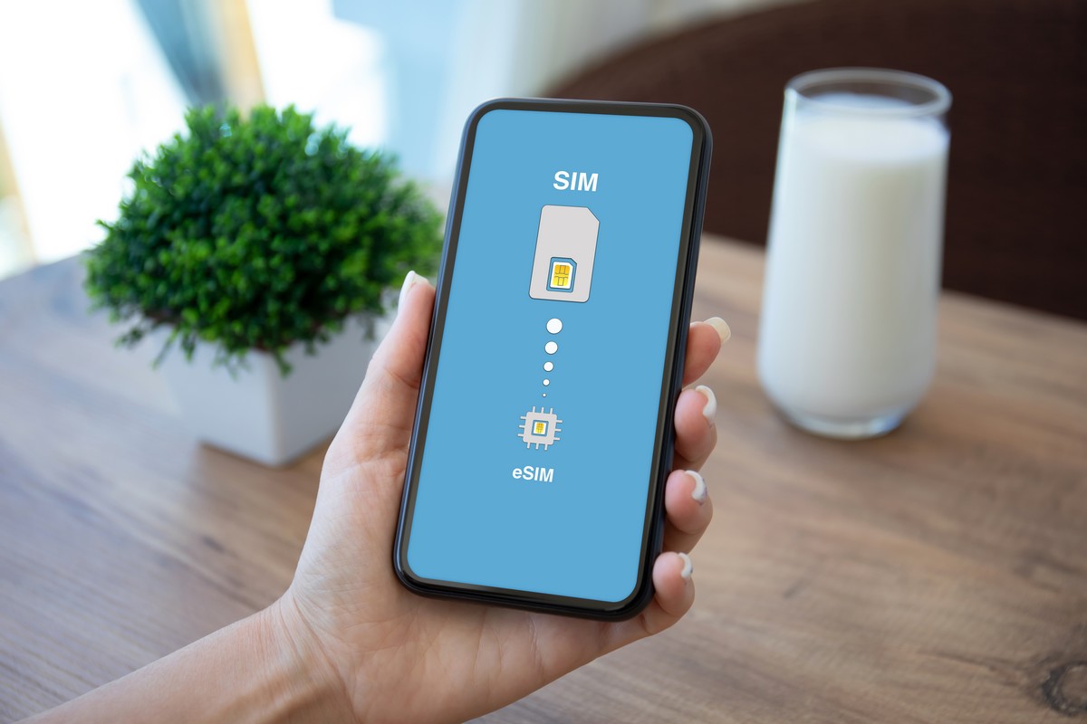 Smartphone dans la main avec eSIM sur l'écran, pratique mais pas toujours compatible