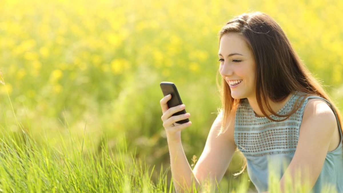 femme avec smartphone dans un champ vert forfait mobile écolo