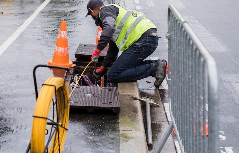 De la fibre optique est installée par un technicien dans la rue
