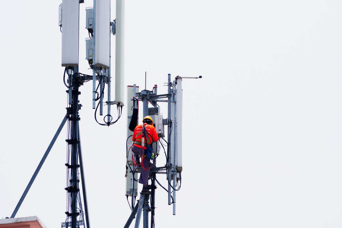 Un technicien déploie une nouvelle antenne 5G sur le toit d'un immeuble