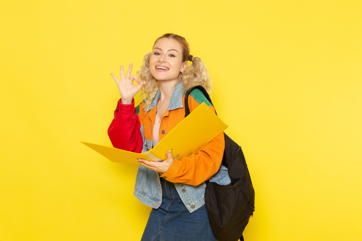Etudiante sur fond jaune avec sac à dos pour la rentrée, prête à choisir la série limitée "Back to School" de Bouygues Telecom