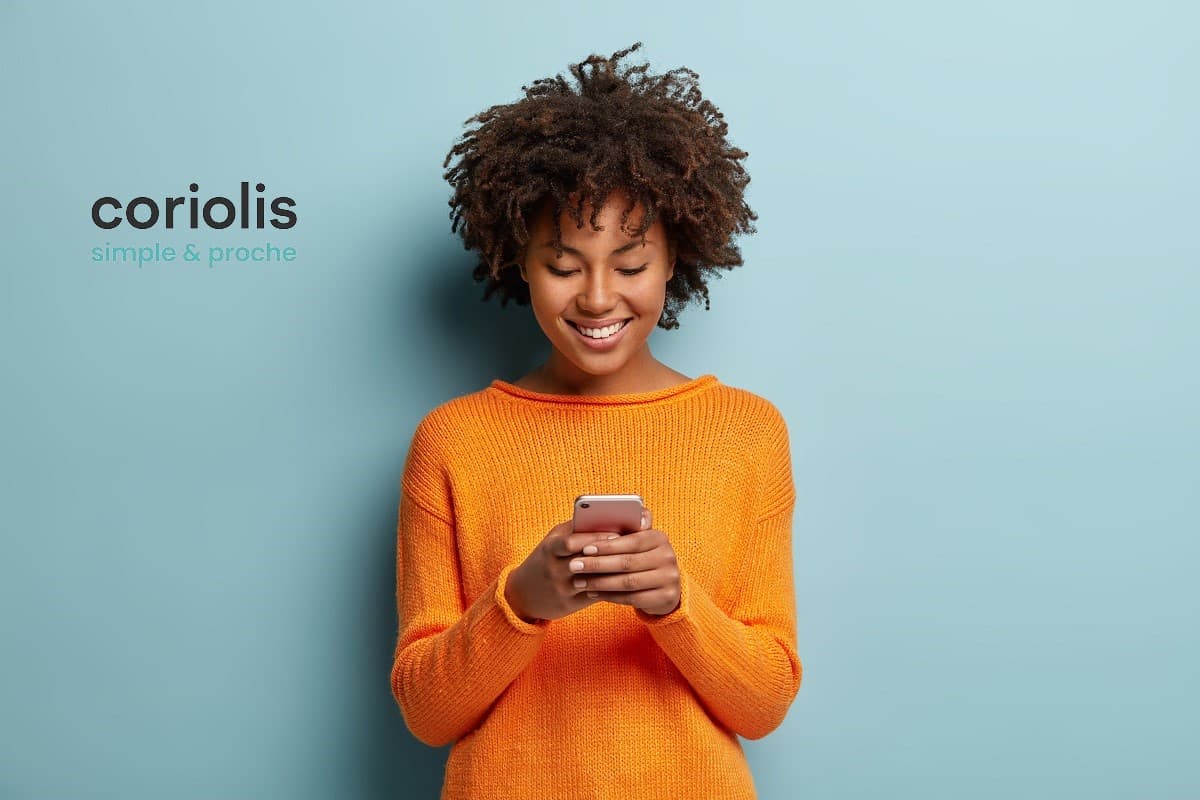 Femme sourit avec son smartphone et son nouveau forfait Coriolis, simple et proche