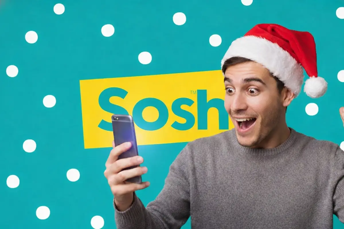 Homme avec bonnet de Noël et logo de Sosh en fond, regarde smartphone, ravi du nouveau forfait 150 Go à 10€