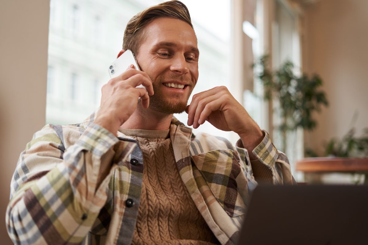 Homme au téléphone sourit, ravi de son forfait de 200 Go en 5G à moins de 7€ grâce à son abonnement Internet Pure Fibre de B&you