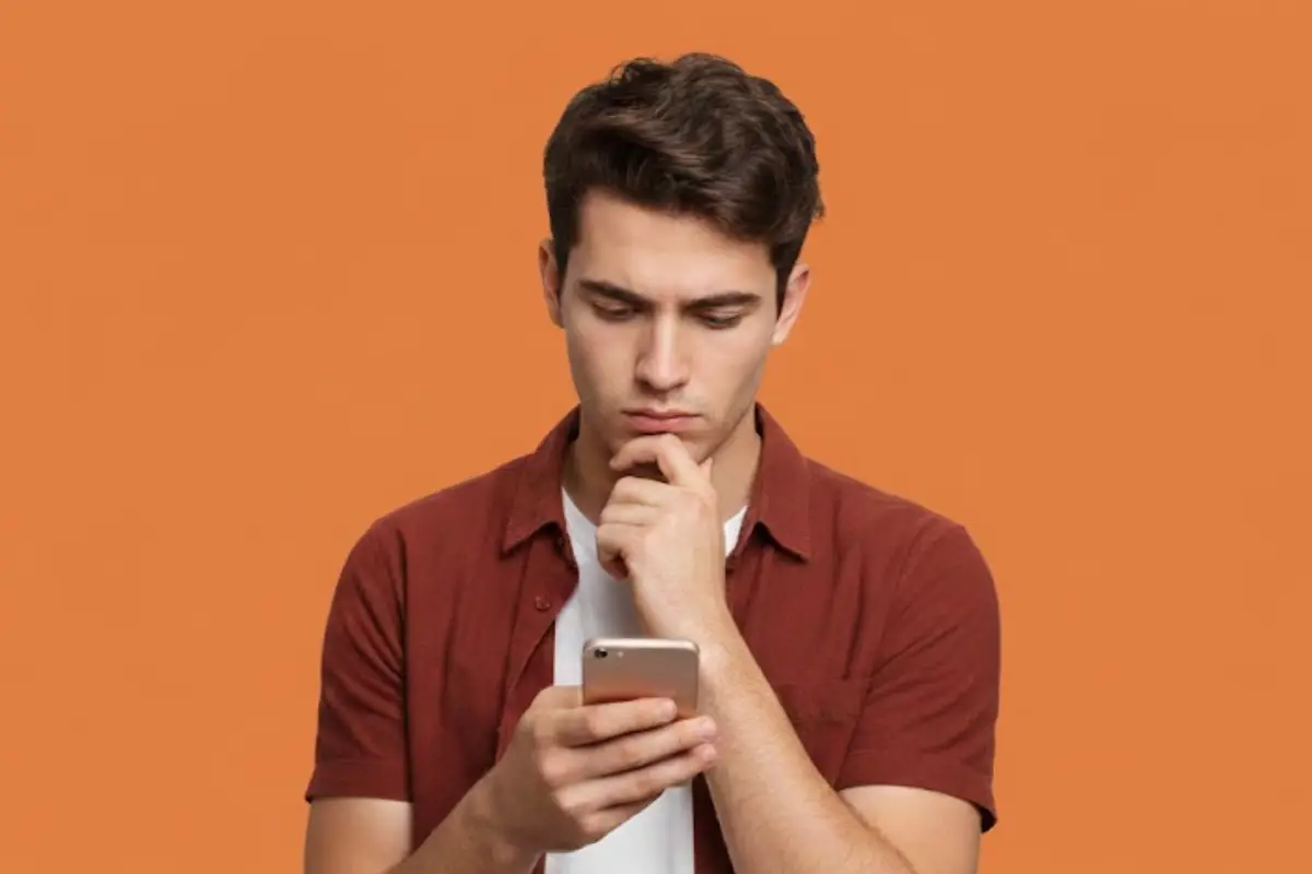 Homme avec smartphone sur fond Orang s'interroge sur le forfait de Sosh, insuffisant